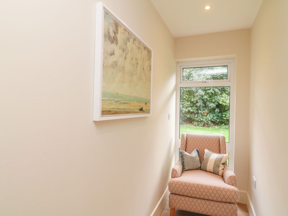 A hallway with an armchair and a painting at The Willows in Mablethorpe