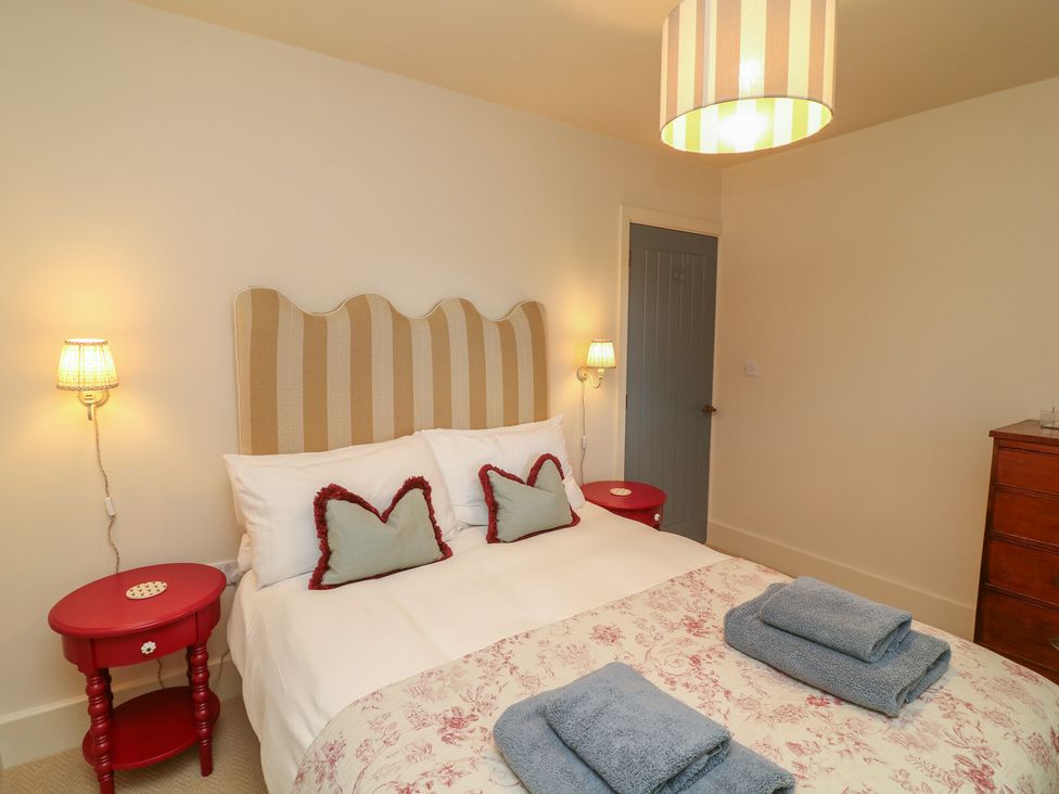 A bedroom with a bed and bedside tables at The Willows in Mablethorpe