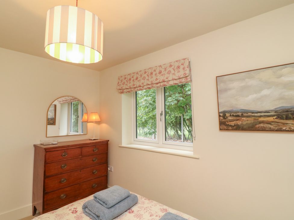 A bedroom with a dresser and a window at The Willows in Mablethorpe