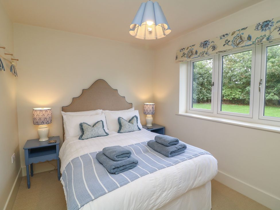 A bedroom with a bed and bedside tables at The Willows in Mablethorpe