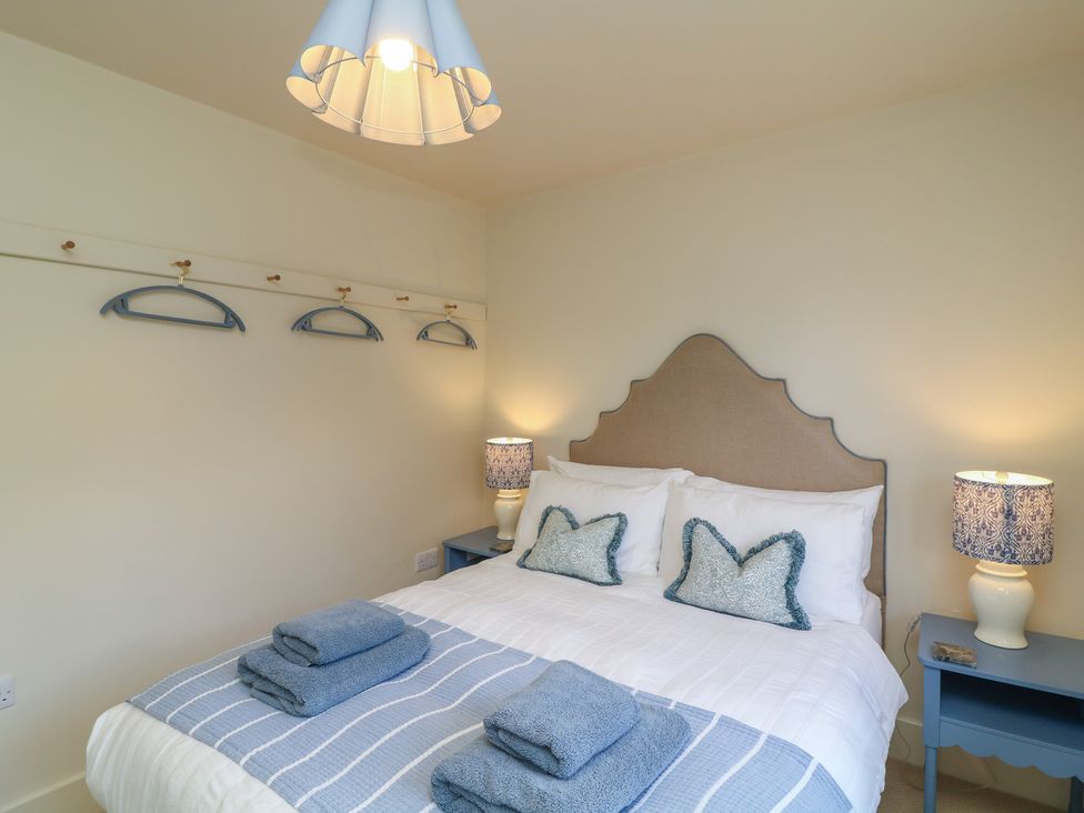 A bedroom with a bed and side tables at The Willows in Mablethorpe