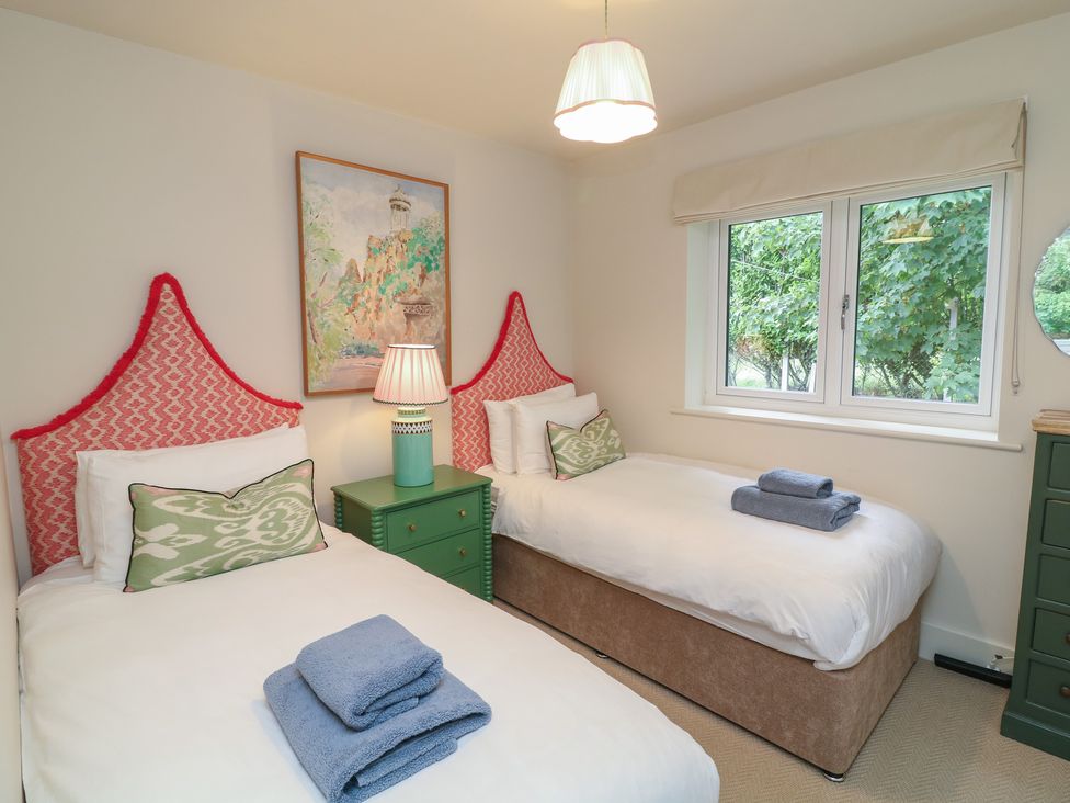 A bedroom with two beds and a window at The Willows in Mablethorpe
