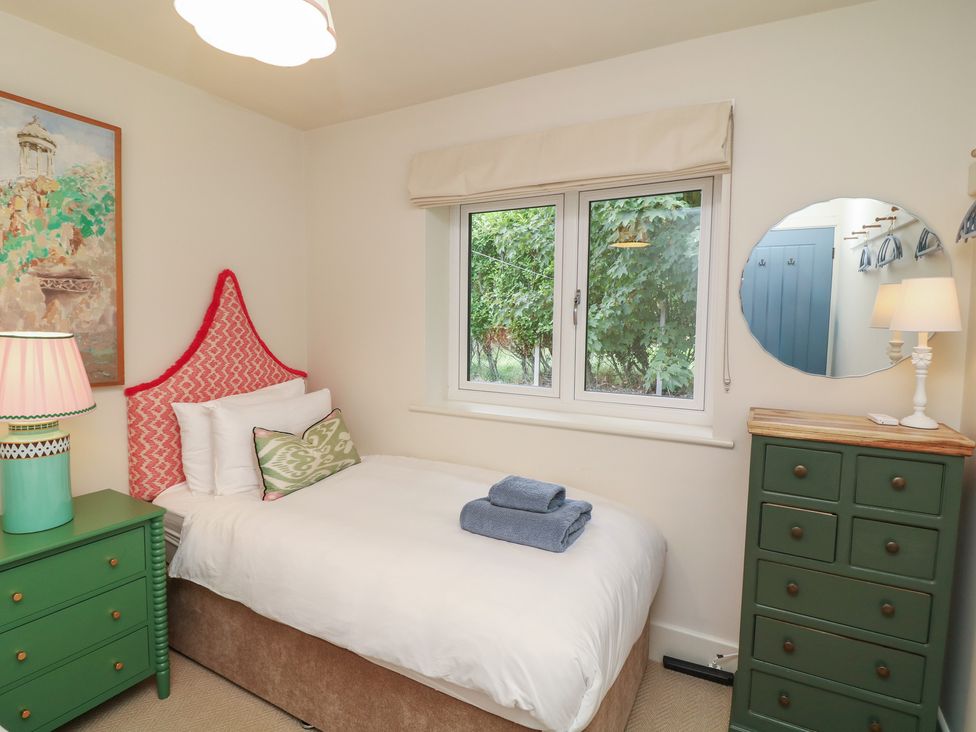 A bedroom with a single bed and green furniture at The Willows in Mablethorpe