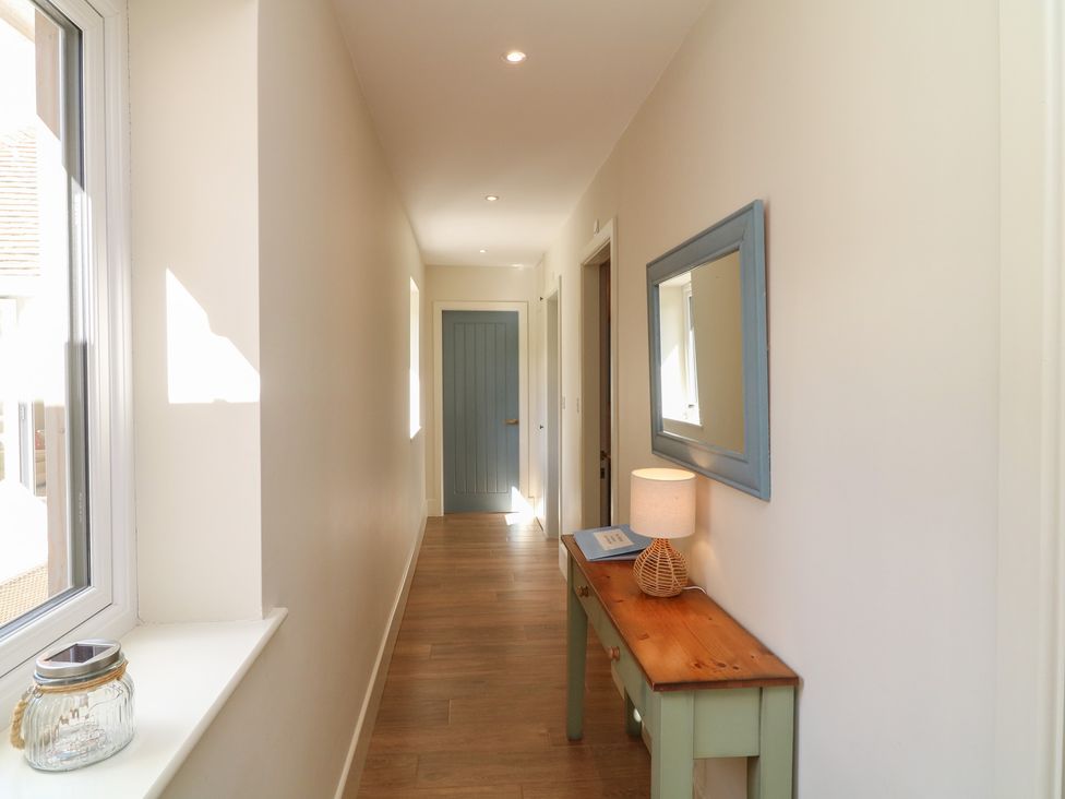 A hallway with a table and lamp at The Willows in Mablethorpe