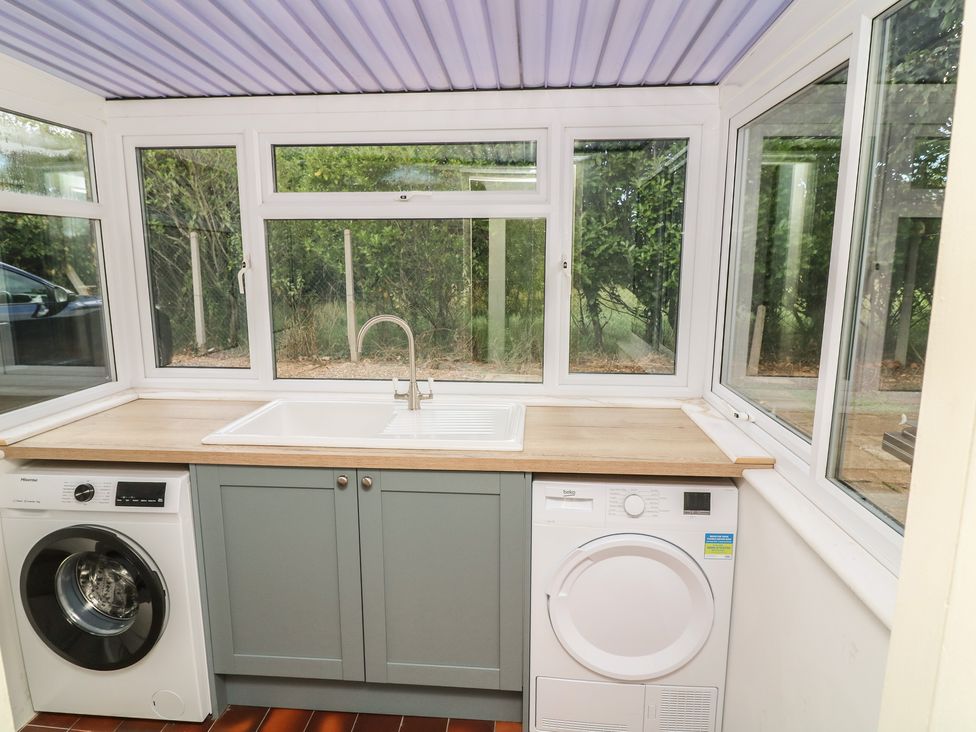 A utility room with a sink and appliances at The Willows in Mablethorpe