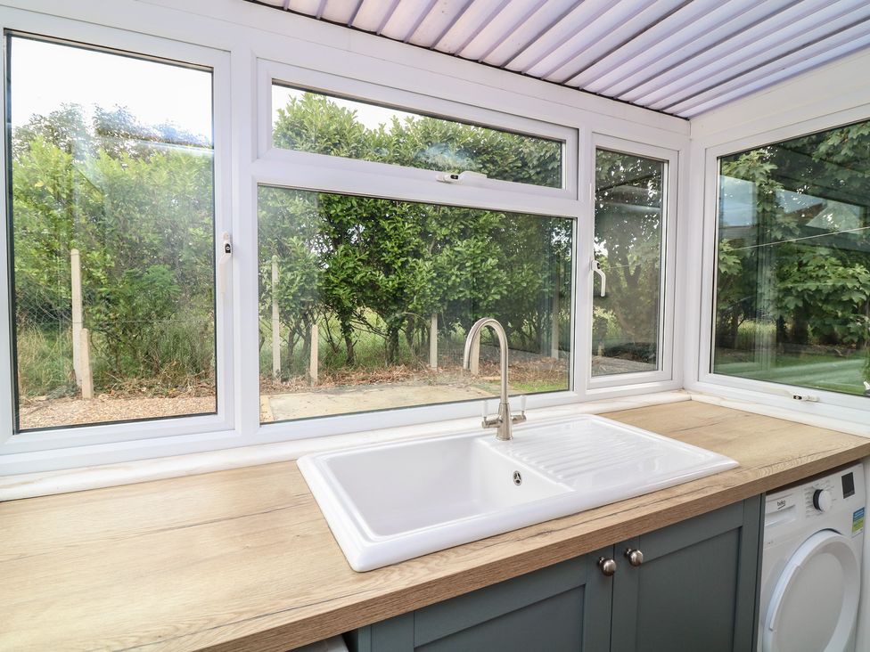 A utility room with a sink and washing machine at The Willows in Mablethorpe