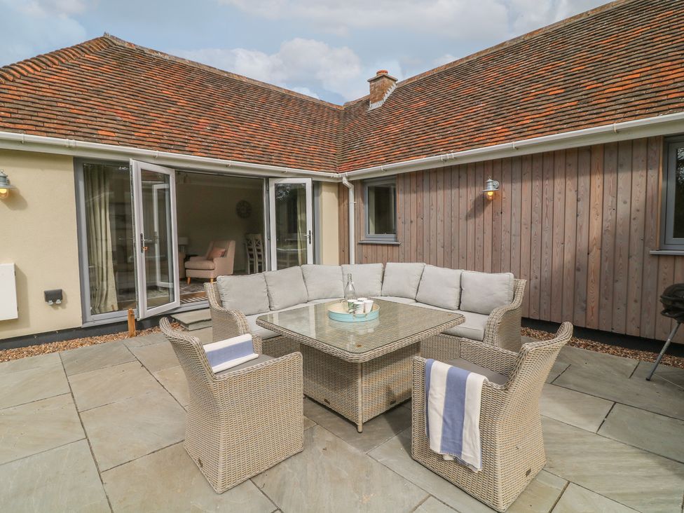 An outdoor seating arrangement with a table and cushions at The Willows in Mablethorpe
