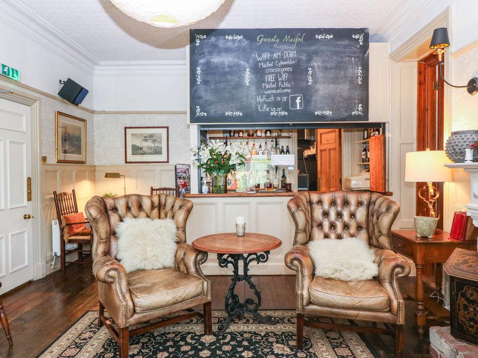 A lounge with armchairs and a bar area at Meifod Country House Caernarfon