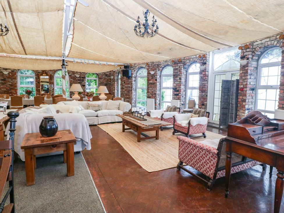A living room with a sofa and dining table at Meifod Country House in Caernarfon