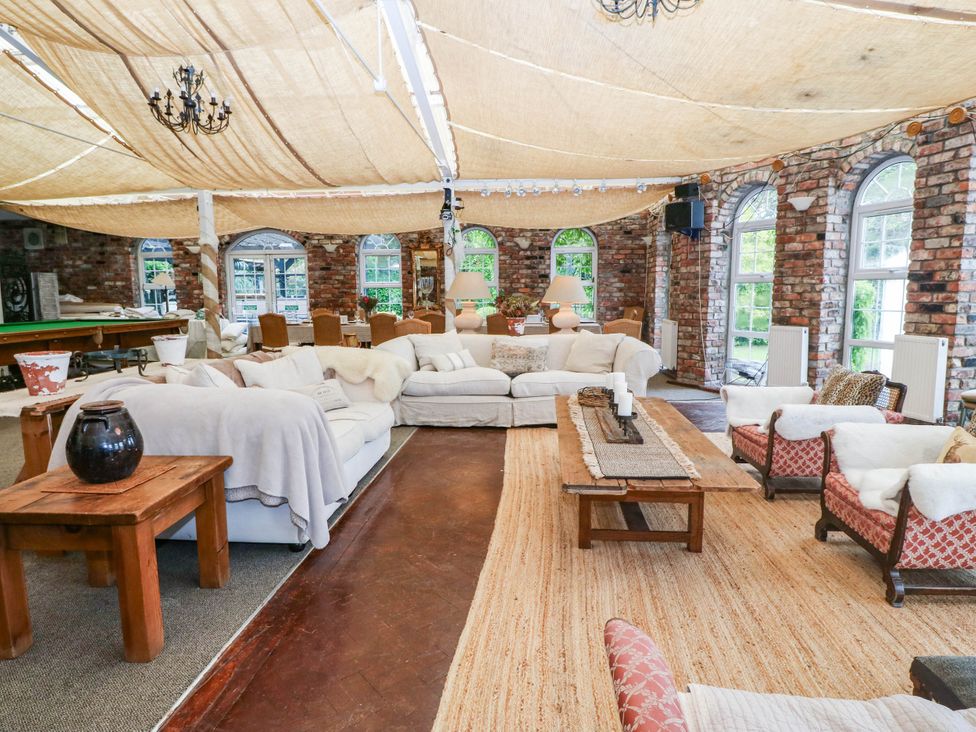 A living room with sofas and a pool table at Meifod Country House in Caernarfon
