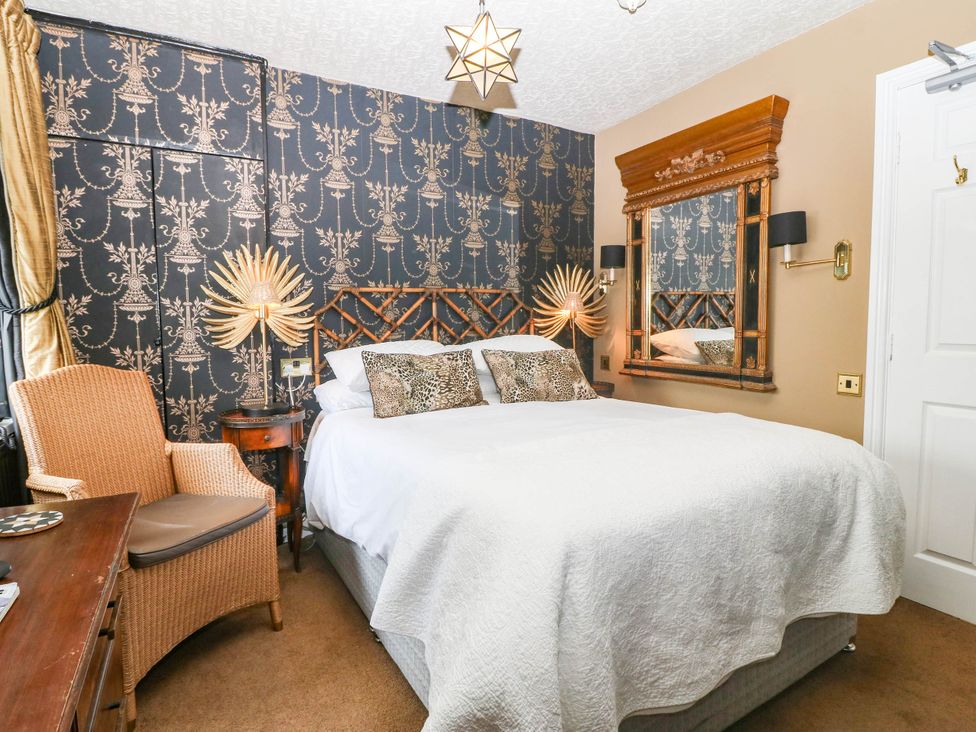 A bedroom with a bed and side table at Meifod Country House in Caernarfon