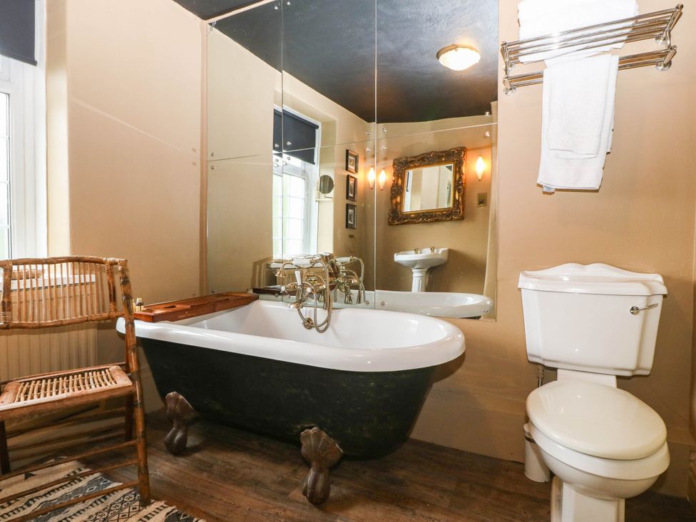 A bathroom with a bathtub, toilet, and sink at Meifod Country House in Caernarfon