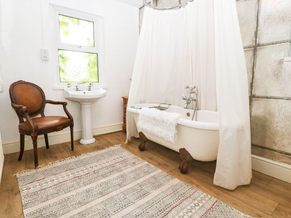 A bathroom with a bathtub and sink at Meifod Country House in Caernarfon