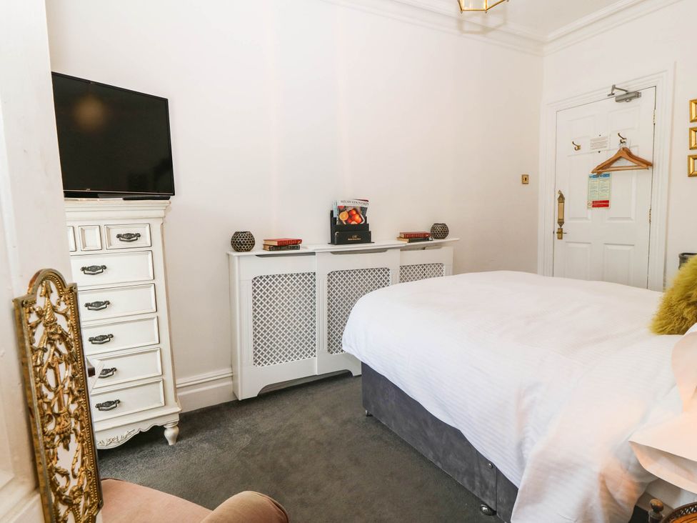 A bedroom with a bed and television at Meifod Country House in Caernarfon
