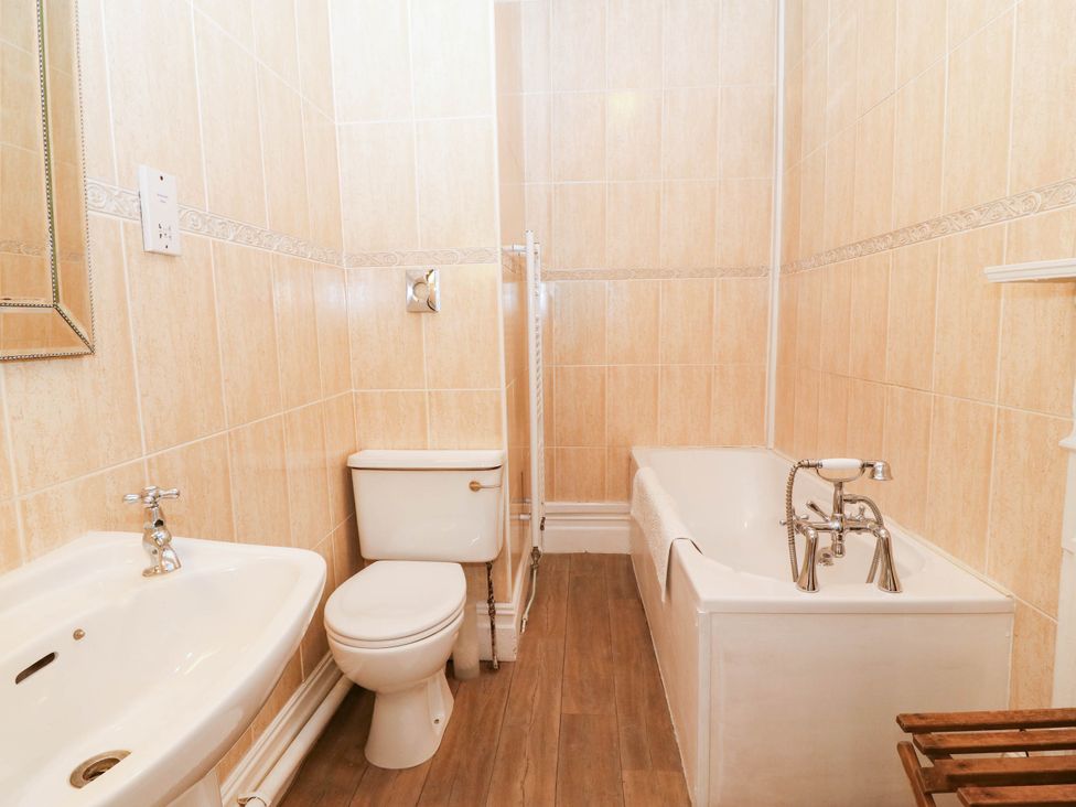 A bathroom with a bathtub, toilet, bidet, and sink at Meifod Country House in Caernarfon