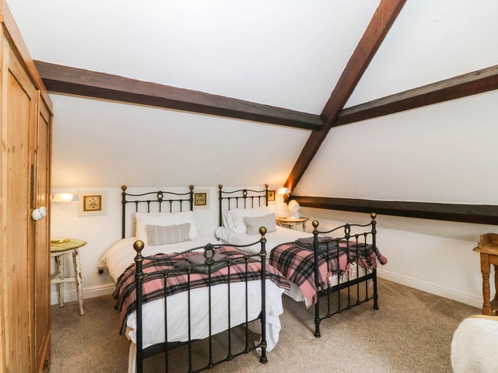 A bedroom with two beds and a wardrobe at Meifod Country House in Caernarfon