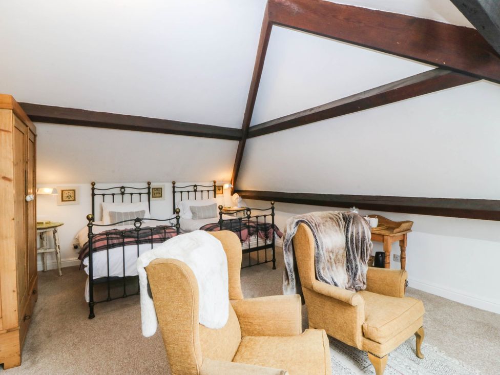 A bedroom with two beds and a wardrobe at Meifod Country House, Caernarfon