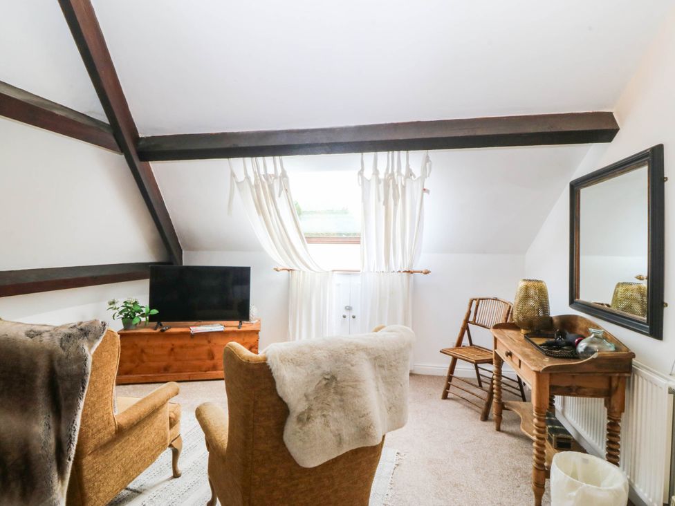 A living room with a television and chairs at Meifod Country House, Caernarfon