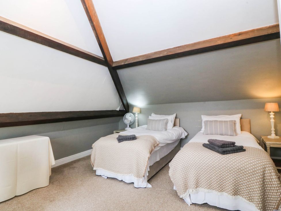 A bedroom with twin beds and a table at Meifod Country House in Caernarfon