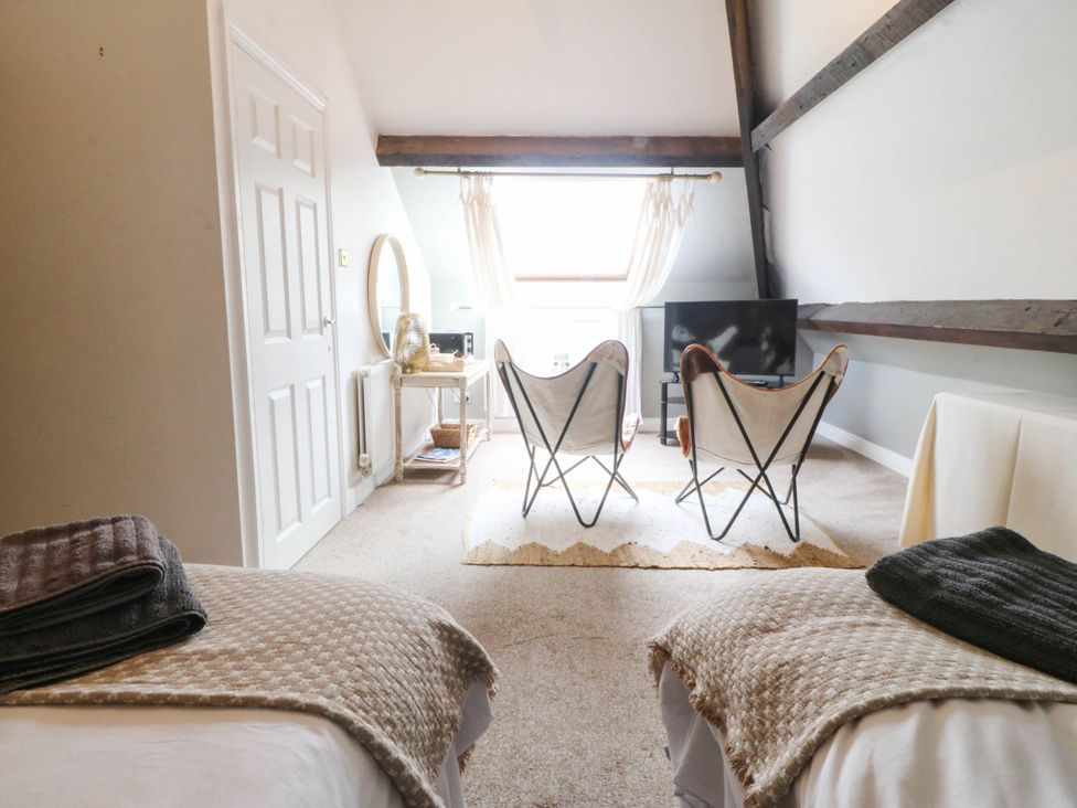 A bedroom with two chairs and a television at Meifod Country House Caernarfon