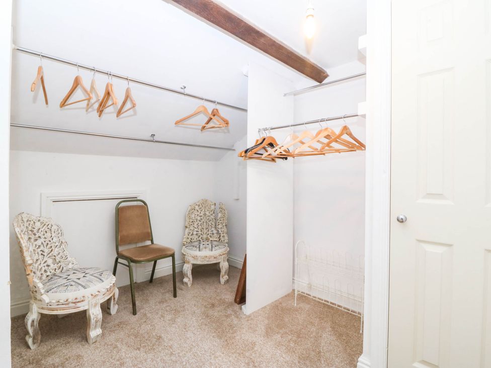 A closet with clothes hangers and chairs at Meifod Country House Caernarfon