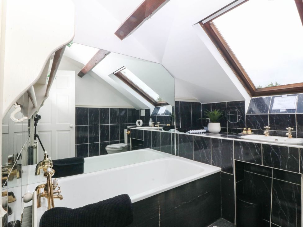A bathroom with a bathtub, toilet, and sink at Meifod Country House, Caernarfon