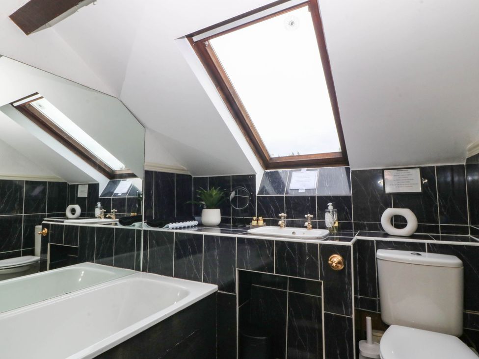 A bathroom with a bathtub and sink at Meifod Country House in Caernarfon