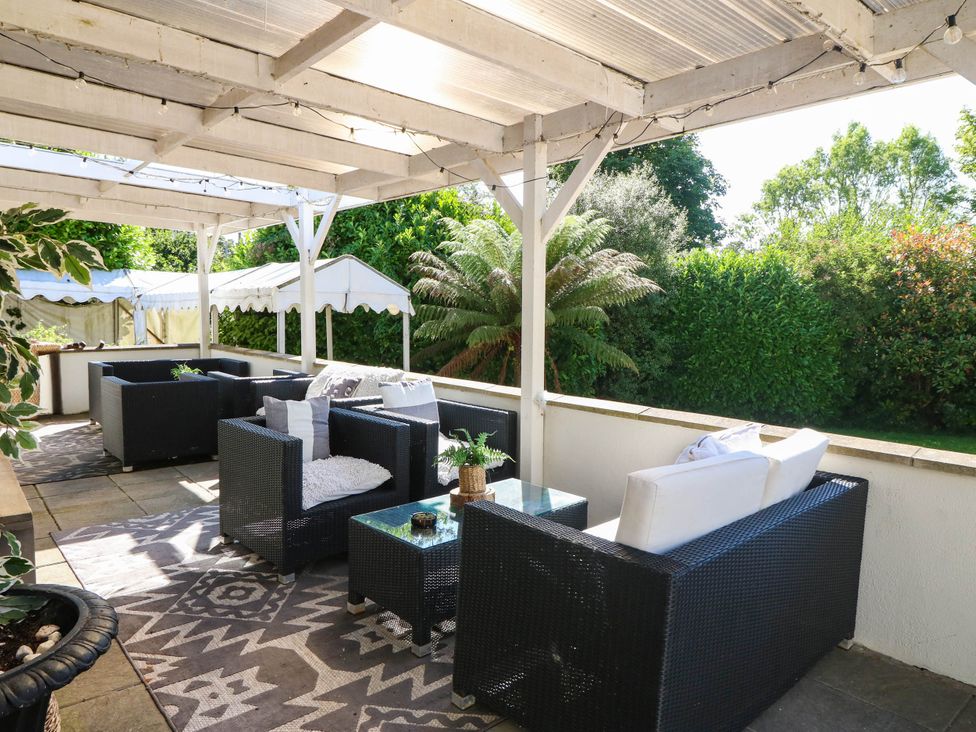 An outdoor patio with seating and a table at Meifod Country House in Caernarfon