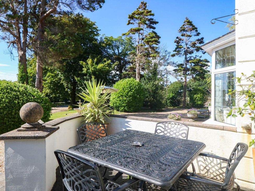 An outdoor seating area with a table and chairs at Meifod Country House in Caernarfon