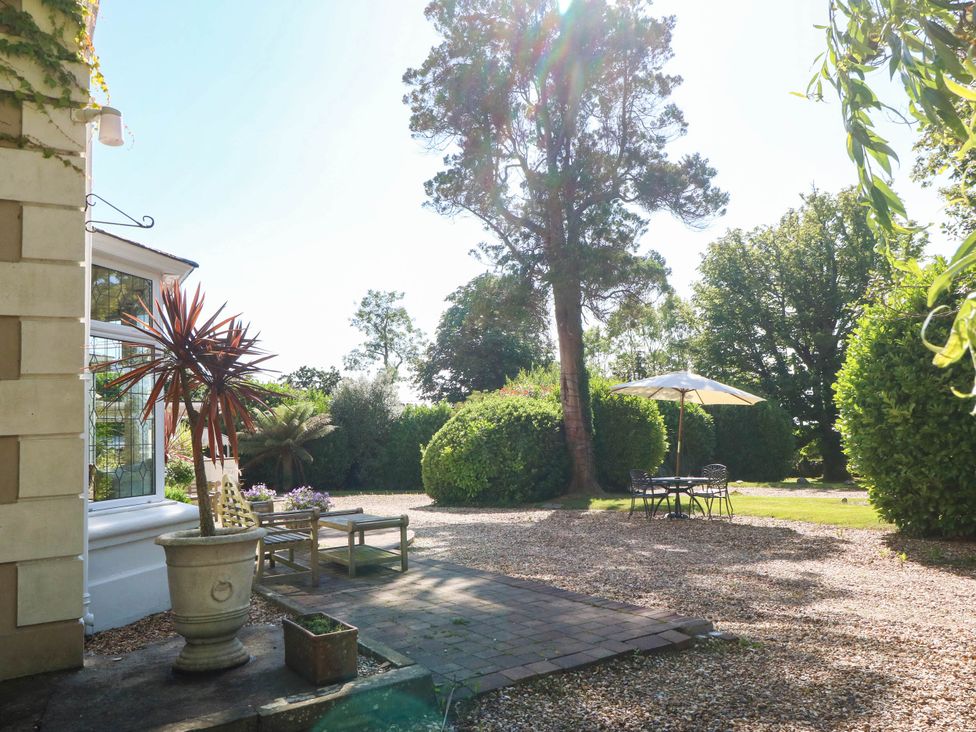 A garden with a table and chairs under an umbrella at Meifod Country House in Caernarfon