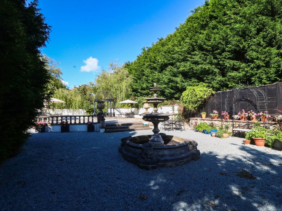 A garden with a fountain and seating area at Meifod Country House in Caernarfon