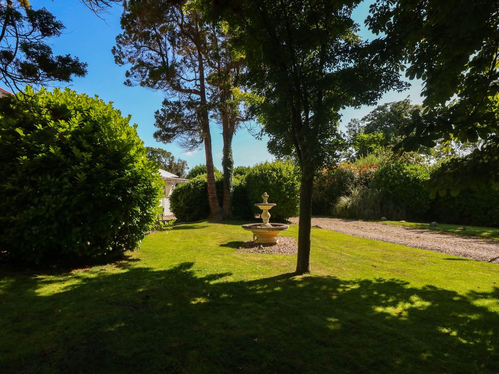 A garden with a fountain and hedges at Meifod Country House Caernarfon