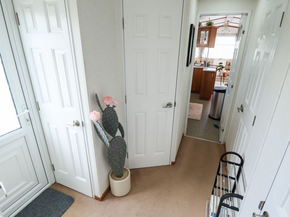 A hallway with a cactus and doors at Atlas in Ingoldmells