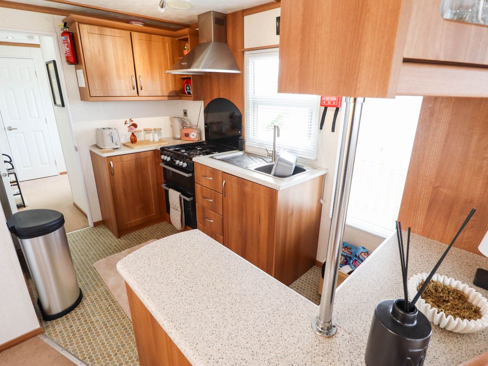 A kitchen with cabinets and appliances at Atlas in Ingoldmells