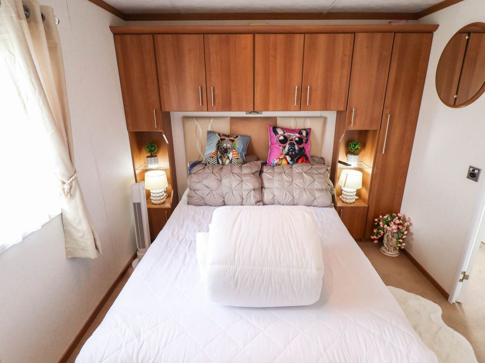 A bedroom with a bed and decorative pillows at Atlas in Ingoldmells
