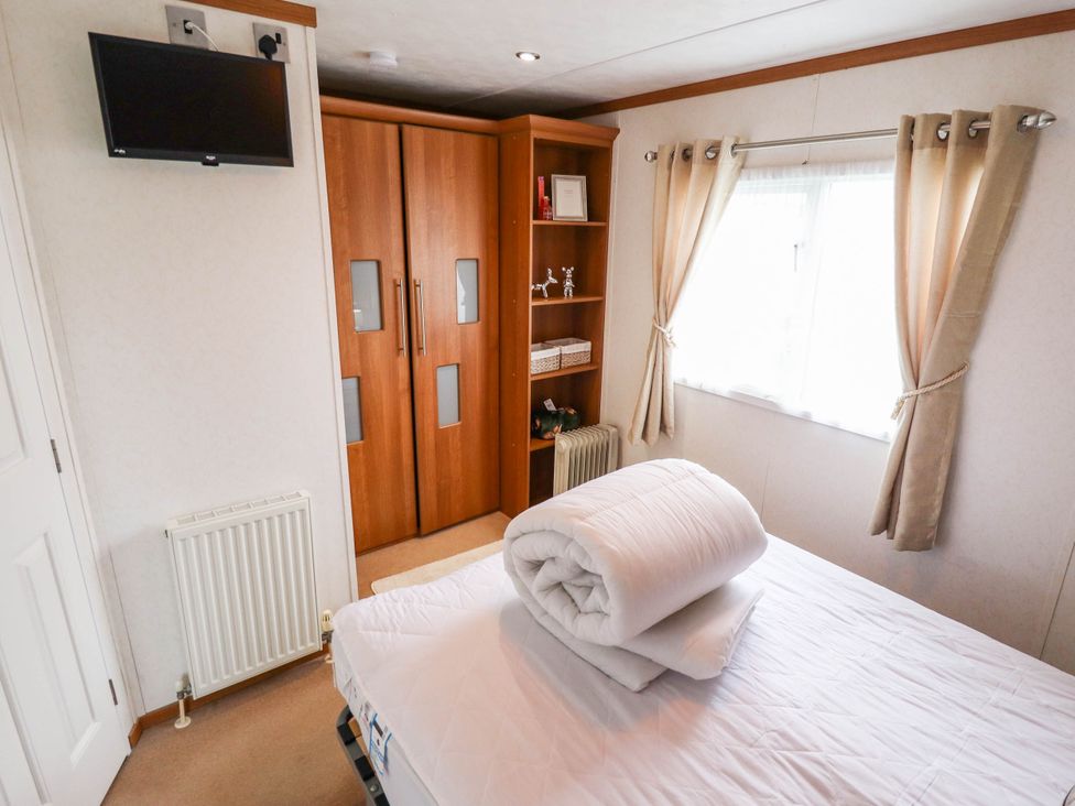 A bedroom with a bed and wardrobe at Atlas in Ingoldmells