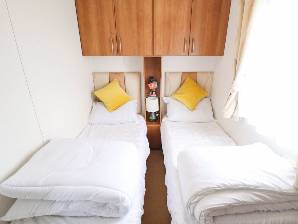A bedroom with two beds and a lamp between them at Atlas in Ingoldmells
