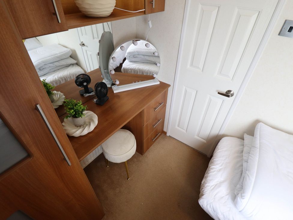 A bedroom with a dressing table and a bed at Atlas in Ingoldmells