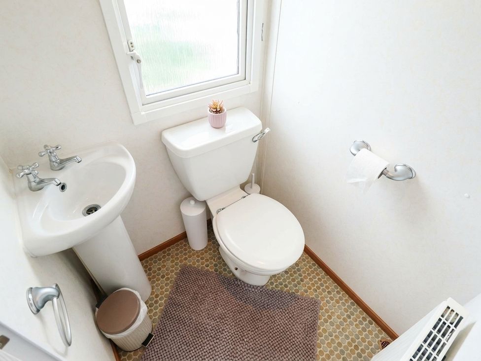 A bathroom with a toilet and sink at Atlas in Ingoldmells