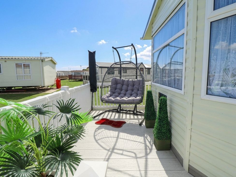 An outdoor area with a hanging chair and planters at Atlas in Ingoldmells