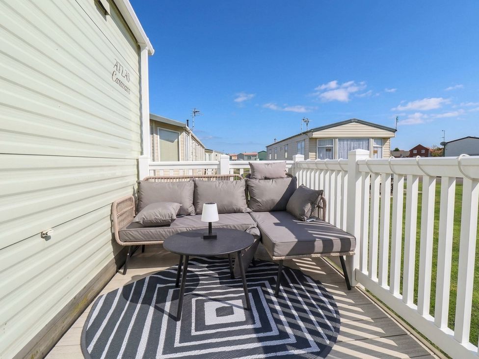 An outdoor seating area with a sofa and coffee table at Atlas in Ingoldmells