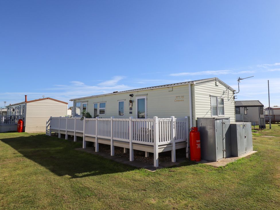 A mobile home with a deck and utility shed at Atlas in Ingoldmells
