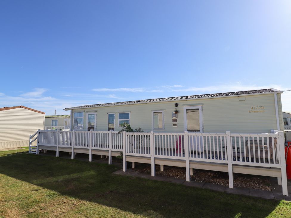 A mobile home with a deck and steps at Atlas in Ingoldmells