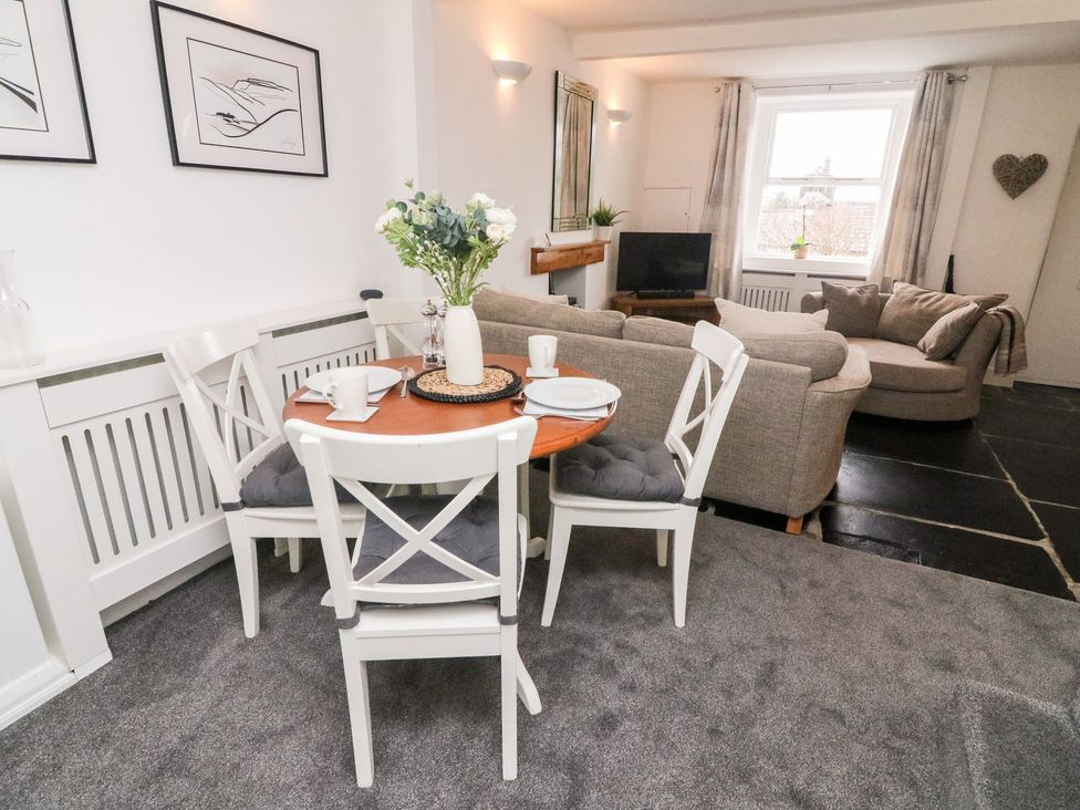 A living room with a dining table and sofa at Crag Cottage Settle