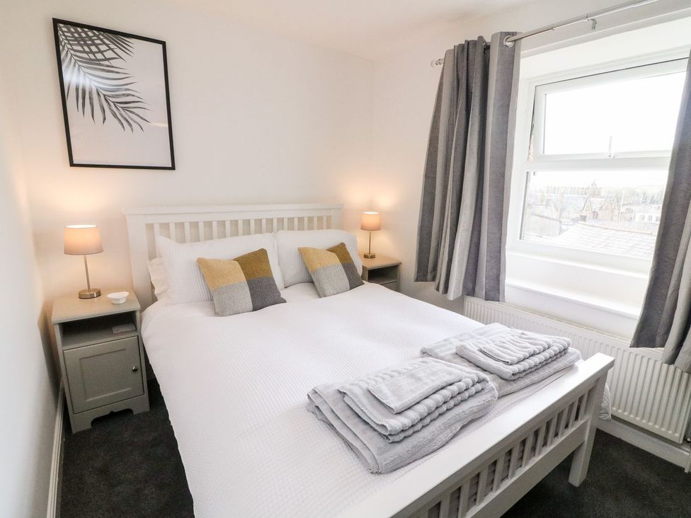 A bedroom with a bed and lamps at Crag Cottage in Settle
