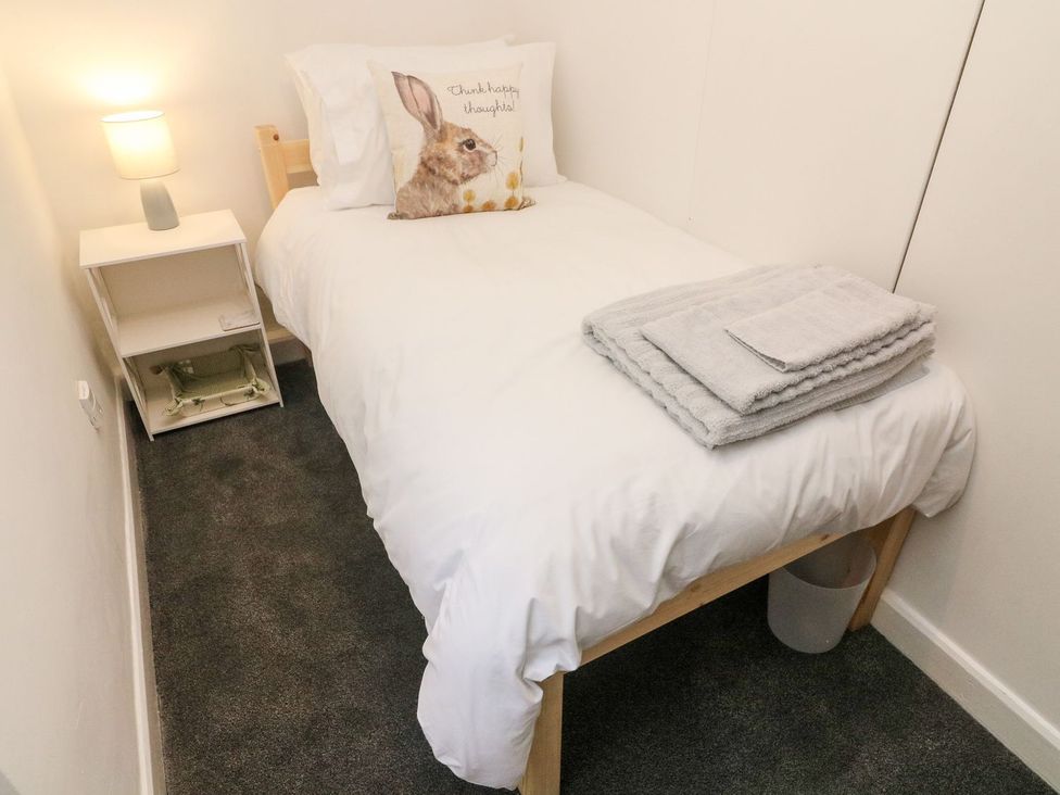 A bedroom with a bed and nightstand at Crag Cottage Settle
