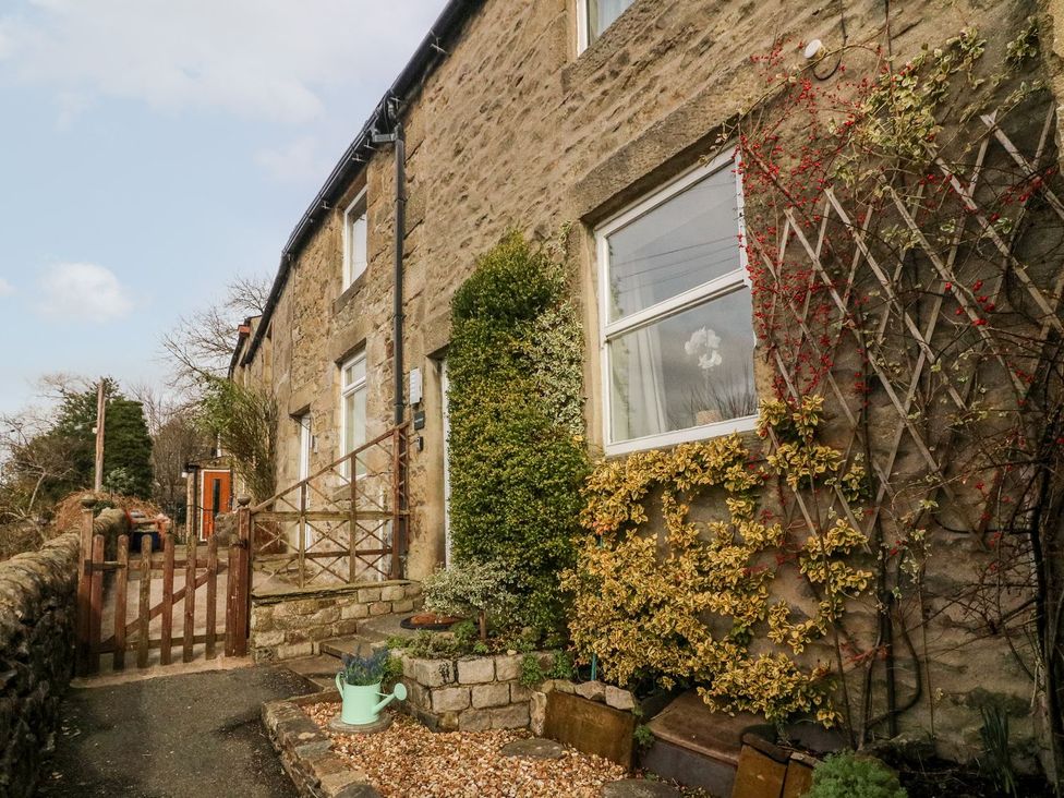 An outdoor view of a stone cottage with a garden at Crag Cottage Settle