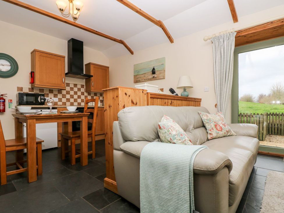 A kitchen with a dining table and appliances at Beech Cottage in Truro