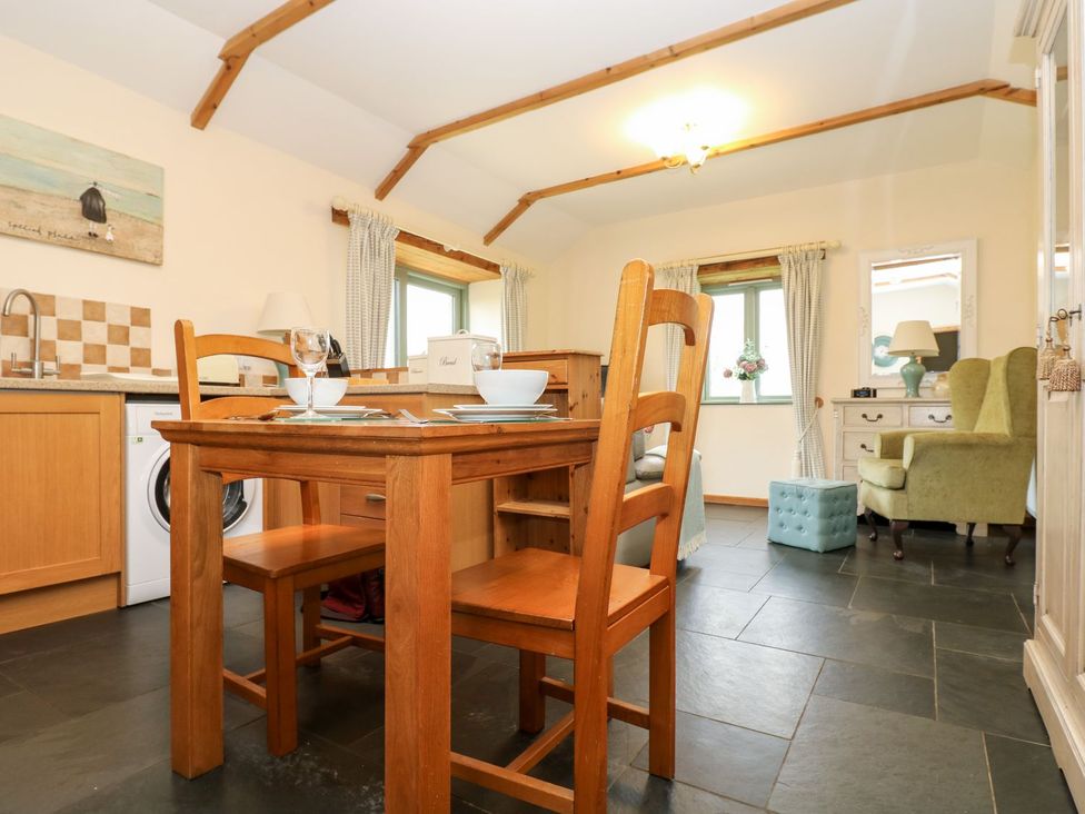 A kitchen with dining area and washing machine at Beech Cottage in Truro