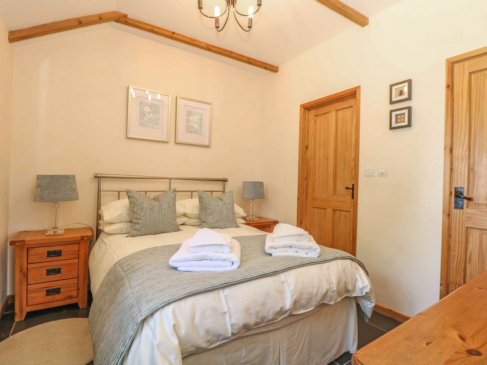 A bedroom with a bed and nightstands at Beech Cottage in Truro
